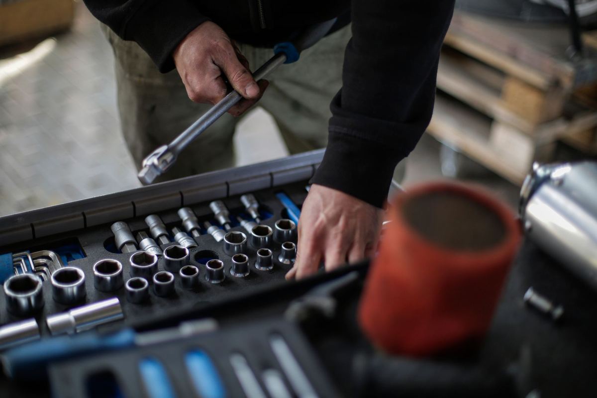 Stock photo: a mechanic picking a socket from an open socket set.