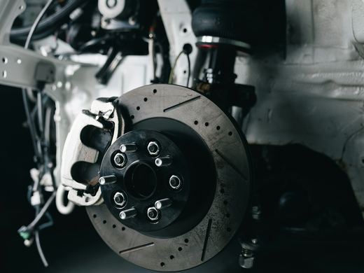 A brake rotor and caliper with the wheel removed. Stock photo.