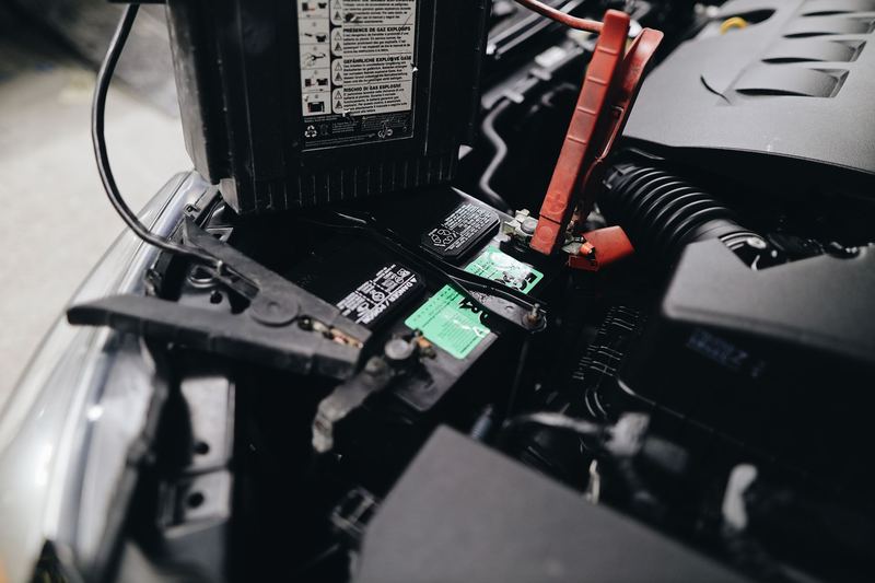 Jumper clamps attached to the terminals of a car battery. Stock photograph.